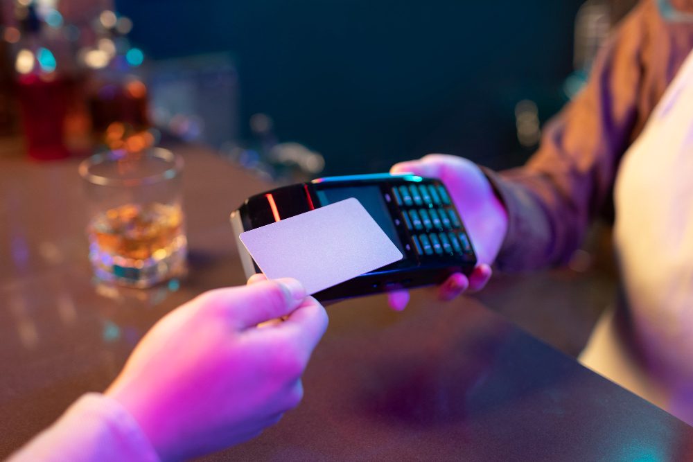 person using a mobile phone to tap an NFC tag to make a payment.